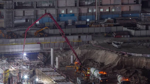 为建造公寓建筑群而在基坑中打桩的时间为夜间飞逝 迪拜的深层安装和挖掘 重型机械如混凝土搅拌机和水泵 推土机 — 图库照片
