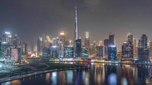 通宵鸟瞰迪拜商业湾和下城的空中风景 以及运河边的各种摩天大楼和塔楼 设有起重机的建筑工地 — 图库照片