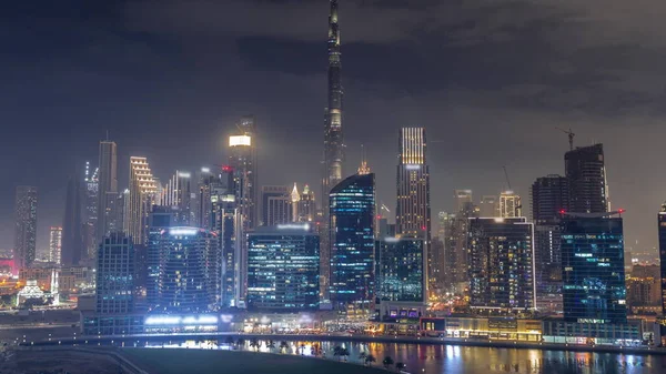 从空中俯瞰迪拜商业湾和市中心 以及沿河畔的各种摩天大楼和塔楼 激光和光显示 设有起重机的建筑工地 — 图库照片