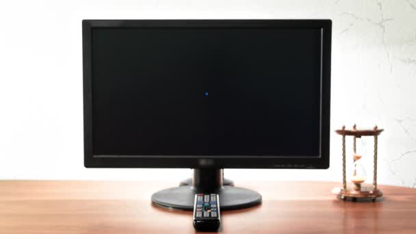 工作台为数字作业配备计算机 沙漏和遥控装置 在显示器前的时间间隔为超时差 移动到黑屏上 — 图库视频影像