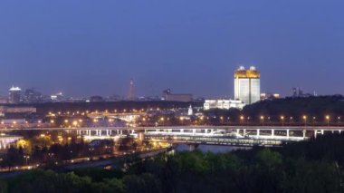 Evening view of the Academy of Sciences and the Shukhov Tower from the observation deck on the Sparrow Hills in Moscow aerial timelapse. Illuminated bridge