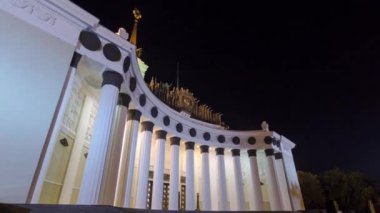 Central Pavilion of VDNH VDNKh exhibition at night in Moscow. Russia. Timelapse and hyperlapse. Front view with illuminated columns