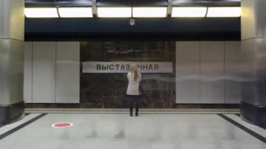 Trenlerin zaman ayarlı olduğu modern bir metro istasyonu. İstasyon isim işaretine bak