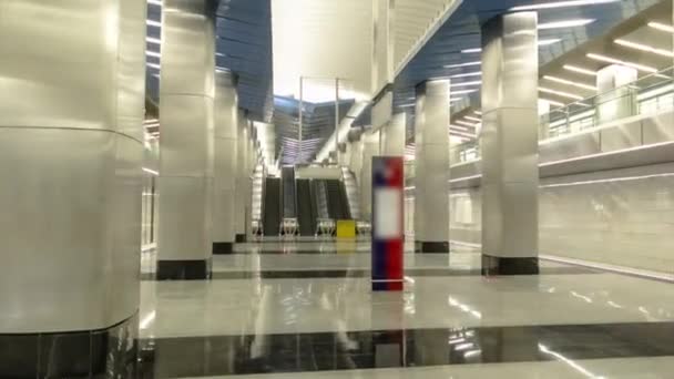 列車のタイムラプスが付いている近代的な地下鉄駅の内部 バックグラウンド上のエスカレーターと階段 — ストック動画