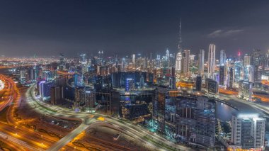 Dubai 'nin modern mimarisi ile panoramik ufuk çizgisi iş sahası ve şehir kuleleri gece gündüz geçiş yapıyor. Gün batımından sonra kanal ve şantiyeli hava manzarası