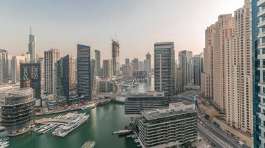 Panorama showing overview to JBR and Dubai Marina skyline with modern high rise skyscrapers waterfront living apartments aerial. Yachts floating on water of canal. JLT district on a background