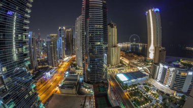 Dubai Marina ve JBR bölgesinin panoraması ve tüm gece boyunca meşhur dönme dolap havası ve ışıkları sönen gökdelenler.
