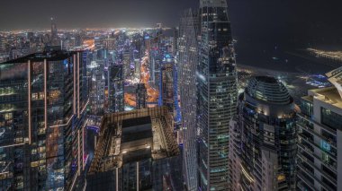 Panorama, Dubai Marina 'yı JLT ve JBR bölgesiyle gösteriyor. Gökdelenler arası karayolunda trafik vardı. Aydınlatılmış modern kuleler ve inşaat alanı