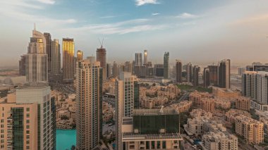 Gün batımında büyük, fütüristik bir şehrin göksel panoramik siluetini gösteriyor. Gökdelenleri ve geleneksel evleri olan iş sahası ve şehir merkezi bölgesi, Dubai, Birleşik Arap Emirlikleri