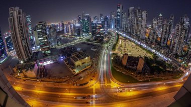 Bay Bulvarı 'nın panoramik ufuk çizgisi. Business Bay hava sahasında modern kuleler, gece geçişi, Dubai, BAE. Büyük otoparkın yakınındaki yolda trafiği olan gökdelenler.