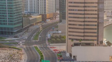Dubai iş sahası bölgesi ofis gökdelenleri ve kavşak anteninde tüm gün boyunca trafik var. İHA kavşağındaki kulelerden ve arabalardan hızlı hareket eden gölgeler.