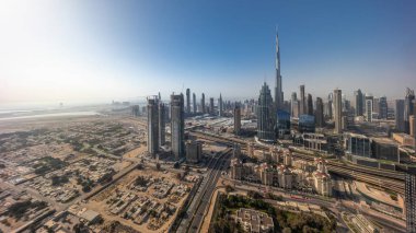 Dubai 'deki en yüksek kulelerin gökyüzü ve karayolunun panoramik görüntüsü. Gündoğumunda akıllı kentlerdeki finans bölgesi ve iş sahası