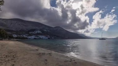 Panorama, mavi gökyüzünde bulutlarla Amorgos adasının havadan zamanlamasını gösteriyor. Geleneksel Yunanistan - tepeleri ve turkuaz denizi olan plaj, Kiklad