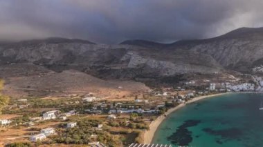 Panorama, gün batımından önce bulutlarla Amorgos adasının havadan zamanlamasını gösteriyor. Geleneksel Yunanistan - tepelerde beyaz evler ve turkuaz deniz, Kiklad