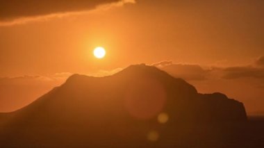 Amorgos adasında gün batımı yukarıdan havadan zaman ayarlı. Geleneksel Yunanistan - dağlık ve tepelerin ve turkuaz denizin üzerinde turuncu gökyüzü, Kiklad