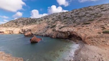 Panorama, Yunanistan 'ın Amorgos Adası' ndaki Navagio Plajı 'nda açık mavi gökyüzünün altında devasa kaya oluşumlarının yakınında, deniz zaman diliminde terk edilmiş, paslı bir gemiyi gösteriyor.