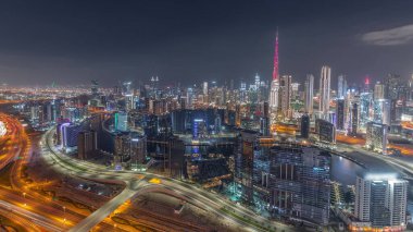 Dubai 'nin modern mimarisi ile panoramik ufuk çizgisi iş sahası ve şehir kuleleri gece gündüz geçiş yapıyor. Gün batımından sonra kanal ve şantiyeli hava manzarası
