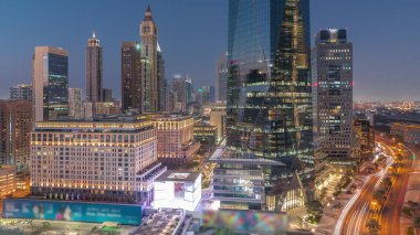 Dubai Uluslararası Finans Bölgesi, günden geceye geçiş. Gün batımından sonra iş yerinin gökyüzü manzarası. Şehir merkezine yakın otelleri ve alışveriş merkezleri olan gökdelenler.