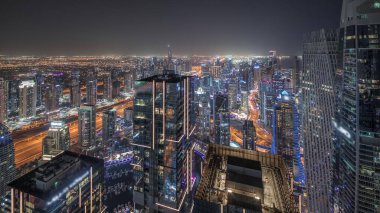 Panorama JBR bölgesini ve Dubai Marina 'yı JLT ile gösteriyor. Gökdelenler arası karayolunda trafik vardı. Aydınlatılmış modern kuleler ve inşaat alanı