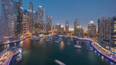 Dubai marinası en uzun gökdelenler ve yatlar liman havasından geceye gün batımından sonra geçiş. Apartman binalarına, otellere ve ofis bloklarına, BAE 'nin modern yerleşim alanlarına bak