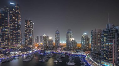Panorama, liman gecesinde Dubai marinasının en yüksek gökdelenlerini ve yatlarını gösteriyor. Apartman binalarına, otellere ve ofis bloklarına, BAE 'nin modern yerleşim alanlarına bak