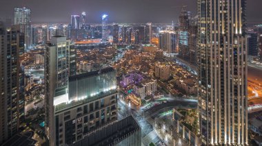 Panorama, büyük, fütüristik bir şehir gecesinin hava görüntüsünü gösteriyor. Dubai, Birleşik Arap Emirlikleri 'nin gökdelenleri ve geleneksel evleri olan iş sahası ve şehir merkezi..