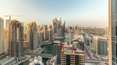 Panorama showing various skyscrapers in tallest recidential block in Dubai Marina aerial with artificial canal. Many towers and yachts