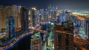 Dubai Marina hava sahasının en yüksek bloğundaki çeşitli gökdelenleri gece gündüz yapay kanallar ve köprüler ile görmek. Gün batımından sonra birçok kule ve yat