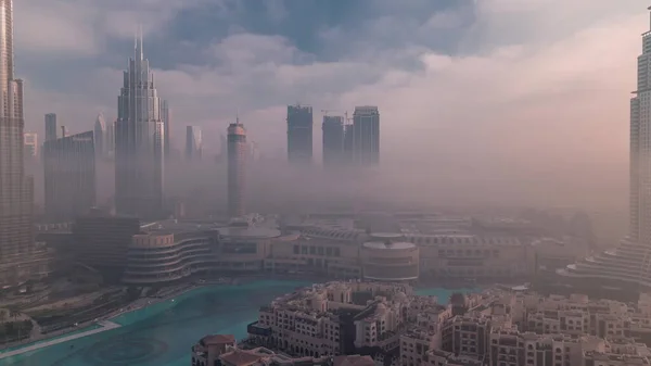 空中的晨雾覆盖了迪拜国际金融中心区 日出时带现代摩天大楼和购物中心的写字楼和酒店 — 图库照片