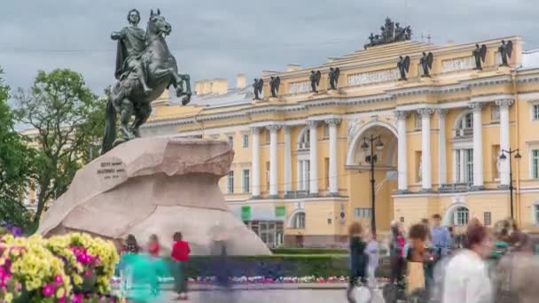 ブロンズ ホースマンは ロシア皇帝ペテロの偉大なタイムラプスの記念碑です ロシアのサンクトペテルブルクの中心部では 曇りの空として写真を撮る観光客が劇的な背景を設定します — ストック動画