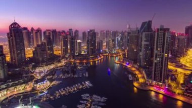 Dubai yat limanı, gece gündüz tekne ve yat panoramasıyla panoramik panoramik aydınlatma ışıkları söner, BAE. Gökdelenleri ve kuleleri olan gökyüzü manzarası