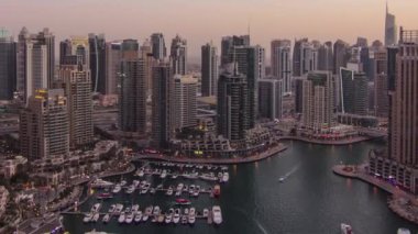 Dubai yat limanı panoraması, gece gündüz tekne ve yat panoraması, geçiş zamanı, aydınlatma ışıkları kapalı, BAE. Gökdelenleri ve kuleleri olan gökyüzü manzarası