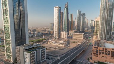 Dubai şehir merkezi ve finans bölgesinde caddelerde trafiği olan fütürist kuleler ve gökdelenler. Kentsel Ufuk Çizgisi hava zaman çizelgesi. Arka planda şehir yürüyüşü