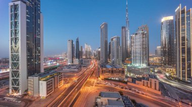 Dubai şehir merkezinin havadan panoramik görüntüsü. Günbekten geceye geçiş zamanına kadar pek çok kule var. Akıllı şehir şehrindeki iş alanı. Günbatımından sonra gökdelen ve yüksek binalar, BAE.