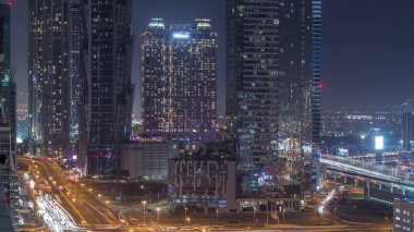 Modern mimari zaman çizelgesi olan Business Bay bölgesi ufuk çizgisi. Yol ayrımında trafik vardı. Dubai gökdelenlerinin ve ana karayolu yakınlarındaki aydınlık kulelerin havadan görüntüsü.