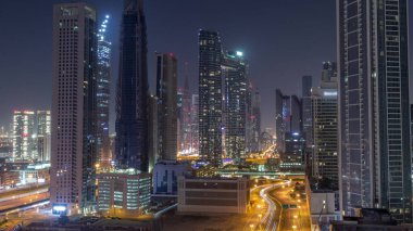 Fütürist kuleler ve ışıklandırılmış gökdelenler Dubai şehir merkezindeki caddelerde ve finans bölgesinde trafik kapalı. Tüm gece boyunca şehir silueti antenleri.