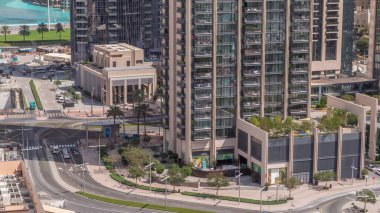 Şehir merkezindeki Dubai şehrinde yoğun yol kavşağı ve kavşakların üst hava görüntüsü. Trafik sıkışıklığından kaçınmak için modern inşaat tasarımı kavşakları ve otoyollar. Gökdelenlere yakın bir sürü araba sürüyor.