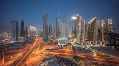 Dubai şehir merkezinin panoramik hava görüntüsü. Günbekten geceye geçiş zamanına kadar pek çok kule var. İş alanı yoğun yol trafiği. Günbatımından sonra gökdelen ve yüksek binalar, BAE