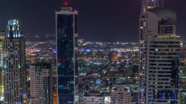 Dubai 'deki Sheikh Zayed Yolu' ndaki yüksek binaların Skyline görüntüsü. Uluslararası Finans Merkezi 'nde yukarıdan aydınlatılmış gökdelenler. Villa evleri arkada.