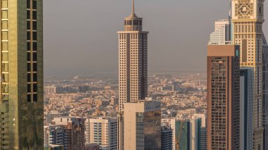 Gün batımında Dubai 'deki Sheikh Zayed Yolu' ndaki yüksek binaların Skyline görüntüsü. Yukarıdan Uluslararası Finans Merkezi 'ndeki gökdelenler. Arka planda birçok villa ve ev var.