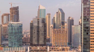 Dubai Business Bay ve şehir merkezinin havadan görüntüsü. Kanal zamanındaki çeşitli gökdelenler ve kuleler. Vinçli inşaat alanı