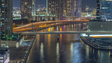 Dubai 'nin Business Bay bölgesindeki su kanalı boyunca yürüme mesafesinde. Rıhtım üzerindeki köprüleri yukarıdan gökdelenlerle aydınlatmak, Birleşik Arap Emirlikleri