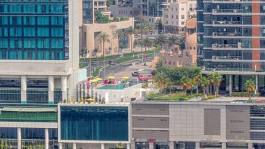 Dubai 'nin Business Bay bölgesindeki su kanalı boyunca yürüyüş gezintisi. Çatı yüzme havuzu ve restoranlar. Rıhtımda köprüler, yukarıdan gökdelenler, Birleşik Arap Emirlikleri