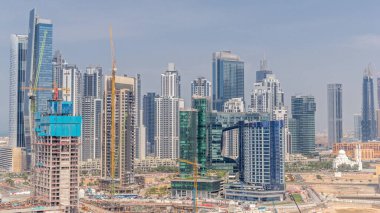 Dubai İşletme Koyu 'nun gökdelenleri ve su kanallarının zaman çizelgesi olan şehir manzarası. Modern gökyüzü ve caminin yakınındaki ofis kuleleri. Yeni bloğun inşaat alanı.