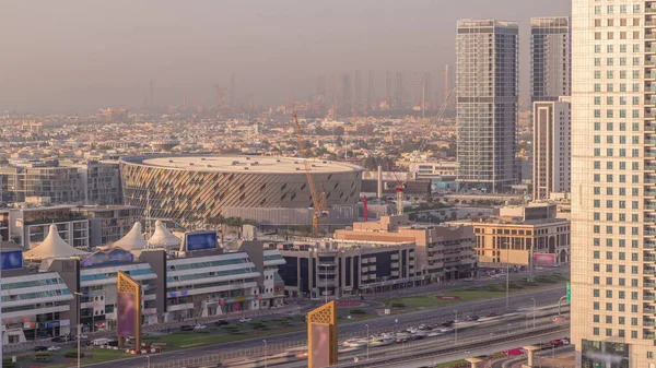 Hava görüntüsünden Dubai Şehir Yürüyüşü 'ne. Düşük katlı binalar, arena ve villaları Avrupa tarzı caddeler olarak yaratılan yeni modern bölüm. Akşam Şeyh Zayed yolunda trafik vardı.