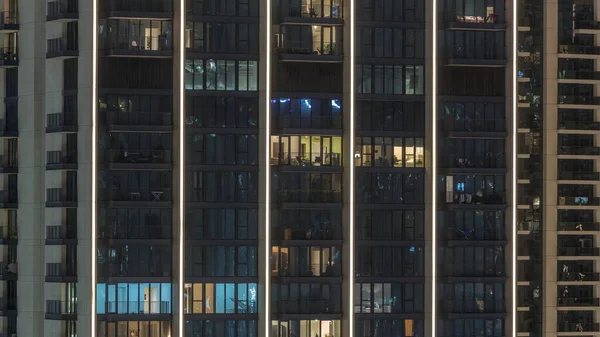 都市空中のタイムラプスの新しい住宅地に位置する輝く窓とフラットの背の高いブロック タワーや高層ビルの部屋の夜の光 — ストック写真