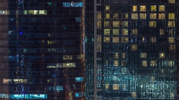 Office and residential buildings windows illuminated at night timelapse. Glass architecture, corporate building at evening with glowing lights