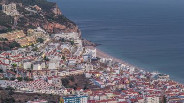 Atlantik Okyanusu 'nun ortasındaki Susimbra Köyü' nün kıyı şeridinin hava görüntüsü. Kale 'nin bakış açısından aydınlatılmış evlerle dolu bir akşam. Portekiz