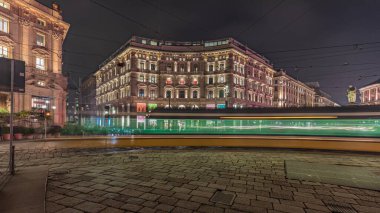 Panorama showing the Cordusio Square night timelapse. Illuminated historic buildings, monument and tram traffic. One of squares in the center of the city at the crossroads of six old streets.