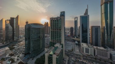 Dubai Uluslararası Finans Merkezi gökdelenleri bulutlu mavi gökyüzü ile panorama Gün batımına kadar tüm gün boyunca hava zaman aralığı. Gölgeler hızlı hareket ediyor ve güneş cam yüzeyden yansıyor.